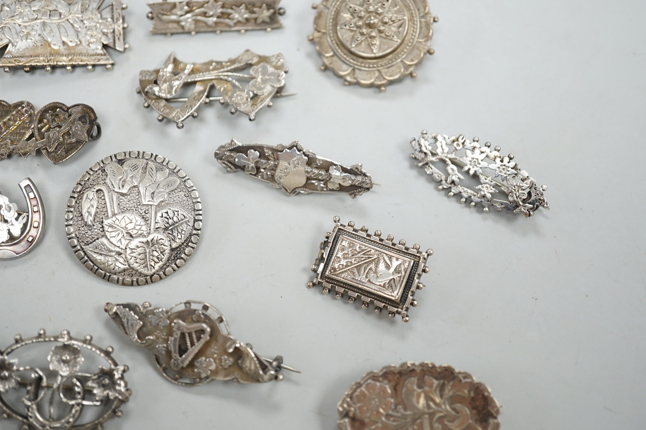 A small collection of twenty nine assorted Victorian and later silver or white metal brooches.